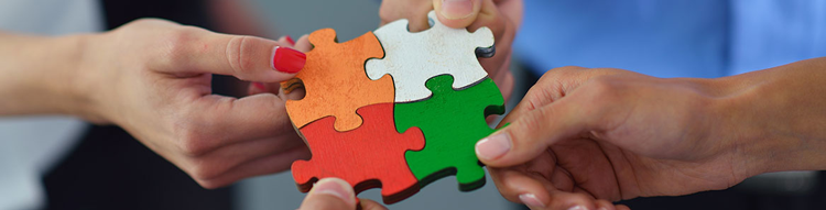 four people combining a seperate puzzle piece